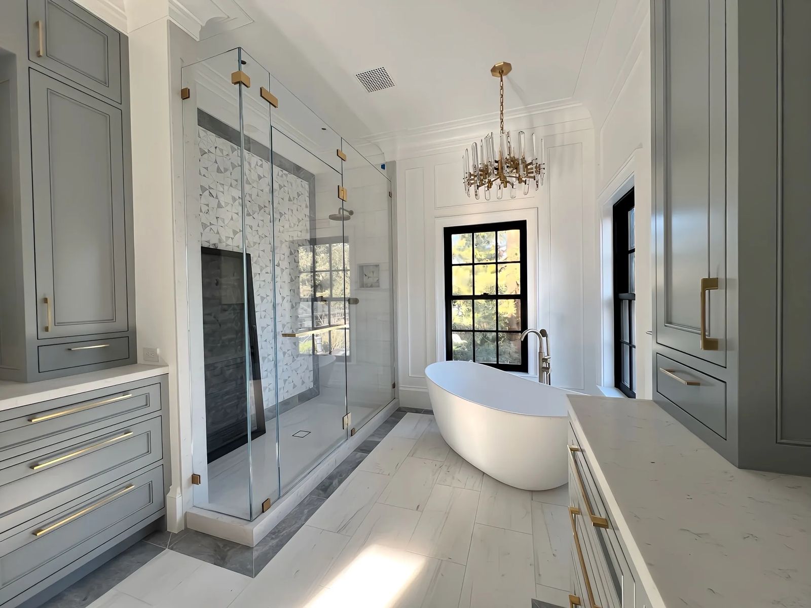 Bathroom with freestanding tub and gray built-in cabinets